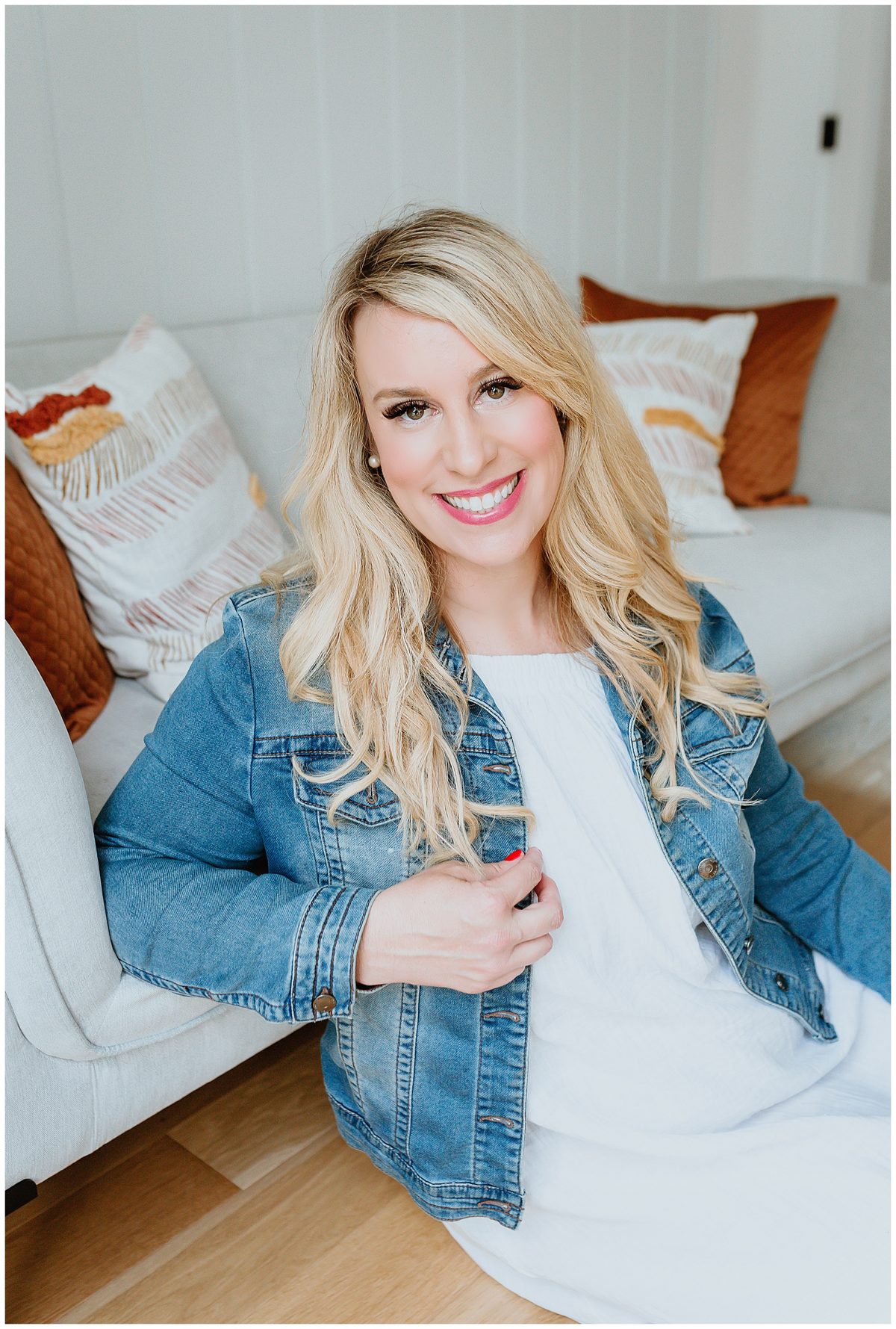 Janna Gobeil in a jean jacket on a white couch
