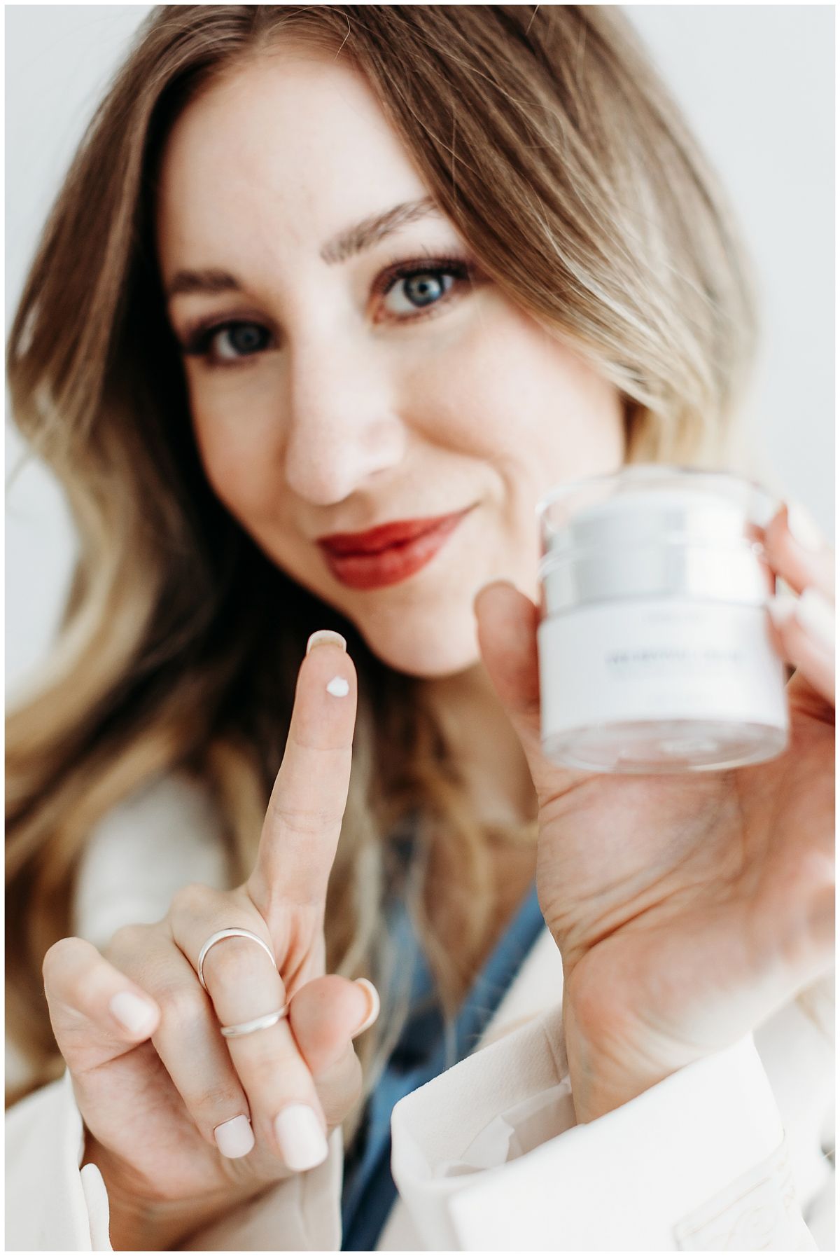 Skincare owner holding a jar of cream