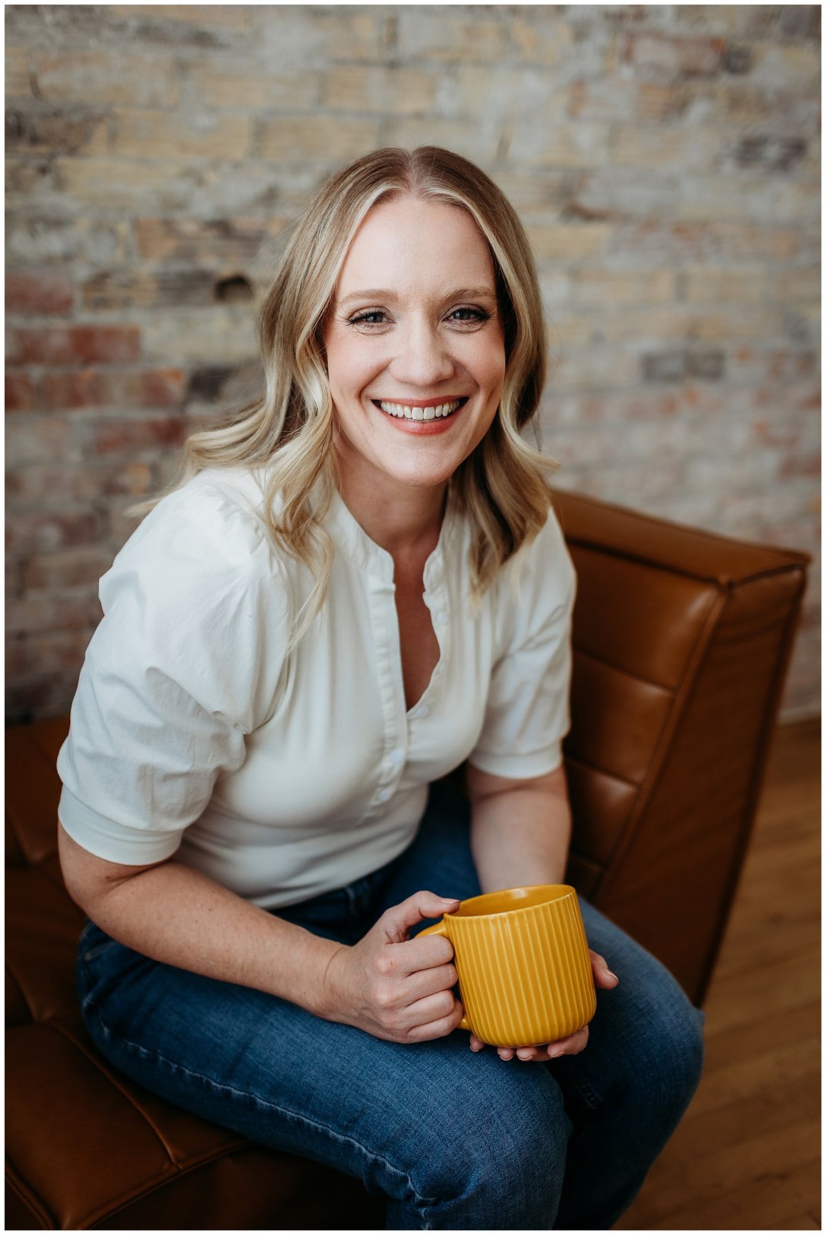 Business owner with a yellow mug on a leather chair